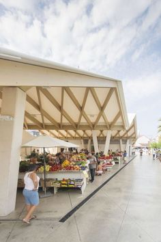 people shopping at an outdoor market under a canopy