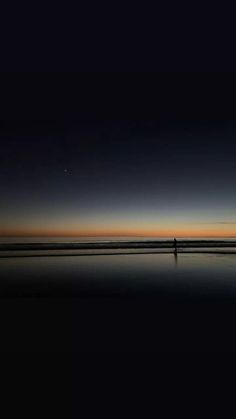 a person standing on the beach at night