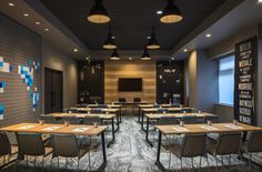 an empty room with tables and chairs in front of a chalkboard on the wall