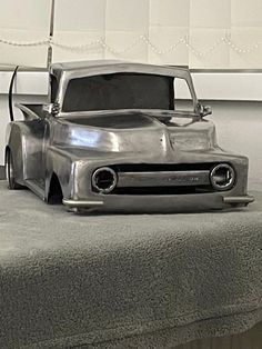 an old model truck sitting on top of a bed in a room with white walls