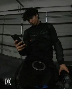 a man in black shirt holding a cell phone