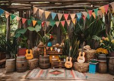 an outdoor party with guitars, hay bales and flags hanging from the ceiling in front of a wooden fence