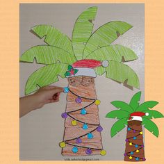 a palm tree made out of construction paper and some string lights on it with a hand