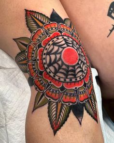 a close up of a person's thigh with tattoos on it and an orange ball in the center