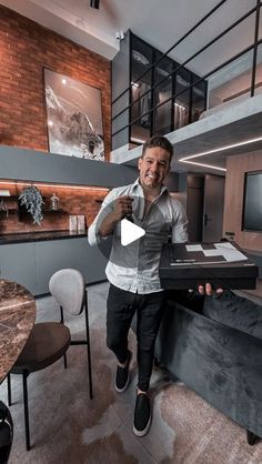 a man is standing in the middle of a living room holding up a tv remote control