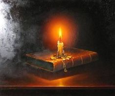 a lit candle sitting on top of a book with the words where your passion goes, your energy flows