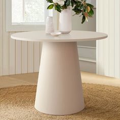 a white table with flowers on it in front of a window and carpeted floor