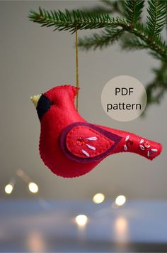 a red bird ornament hanging from a christmas tree