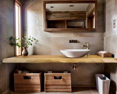 a bathroom with a sink, mirror and two baskets on the counter next to it