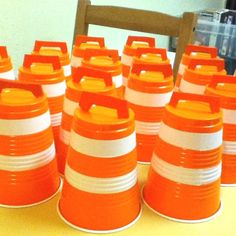 orange and white striped cups sitting on top of a table