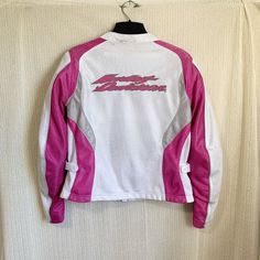 a white and pink jacket hanging on a wall