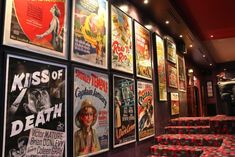 a row of red chairs sitting next to a wall covered in movie posters