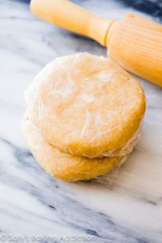 two pastries sitting next to a rolling pin on top of a marble countertop