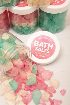 bath salts in small jars with pink, green and yellow candies next to them