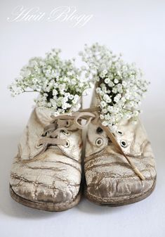 a pair of gold shoes with baby's breath flowers in them