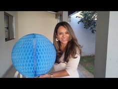 a woman is holding a blue ball in front of her face and smiling at the camera