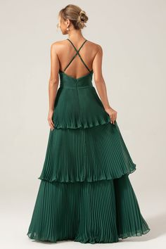 the back of a woman wearing a green dress with pleated skirt and halt neck