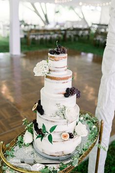 a white wedding cake sitting on top of a green table next to a wooden floor