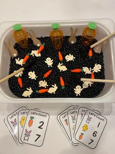 a tray filled with lots of black beans and carrots on top of each other