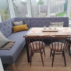 a couch and table in a room with large windows