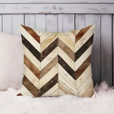 a chevroned wooden pillow sitting on top of a white furnishing covered bed