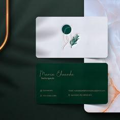 two business cards sitting next to each other on top of a green and white surface