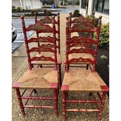 two red chairs sitting next to each other in front of a building