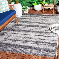 an outdoor area with wooden flooring and plants