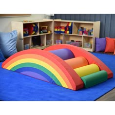 an inflatable rainbow bed is on display at a children's playroom