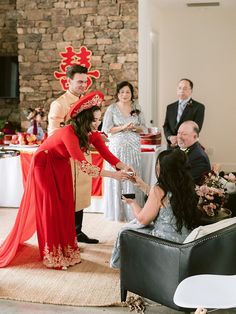 a woman in a red dress standing next to a man