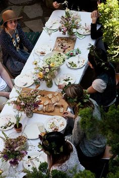 a group of people sitting around a table with food on it