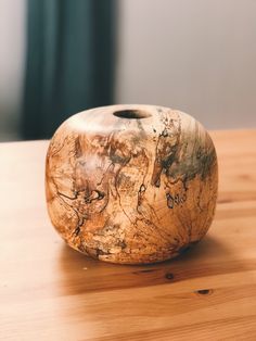 a wooden vase sitting on top of a wooden table