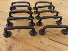 six cast iron door handles on a wooden floor