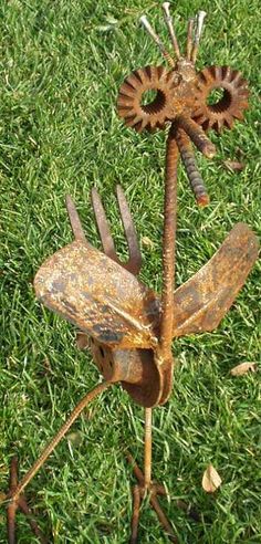 an image of a rusted metal insect on the grass