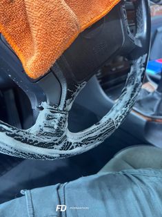 the interior of a car with an orange cloth on it's steering wheel cover