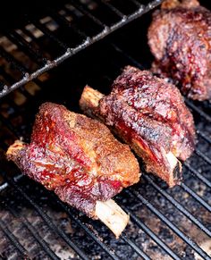 two steaks are cooking on the grill