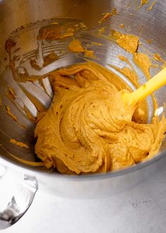 a metal mixing bowl filled with yellow batter