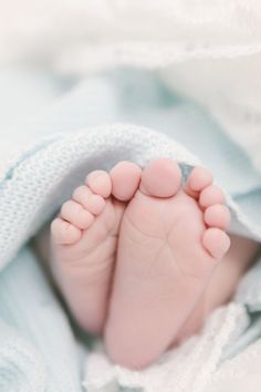 a close up of a baby's feet under a blanket