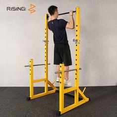 a man is doing squats on a yellow pull - up bar in the gym