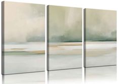 three abstract paintings with white and green colors on the wall, one in grey and beige