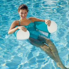 a woman holding two frisbees in a pool with a dolphin swimming behind her