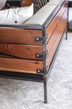 a wooden bed frame with metal straps on the bottom and footrests, in a living room