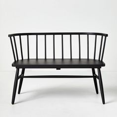 a black wooden bench sitting on top of a white floor