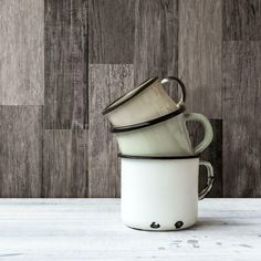 three coffee cups stacked on top of each other in front of a wooden paneled wall