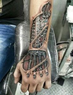 a man with a tattoo on his arm and hand is holding an object in the shape of a skeleton