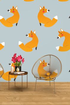 a room with two chairs and a table in front of a wall with foxes on it