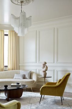 a living room filled with furniture and a chandelier