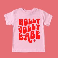 Holly Jolly Babe Christmas Shirt Feature Picture is a Pink Tee with Red Design Wash: For best results wash inside out on cold and line dry. DO NOT IRON directly on the image All our designs are printed with high quality heat transfer vinyl. The designs are applied using a professional commercial grade heat press and are made to last. All items are made to order in the order in which they are received so please allow 5 business days for your order to be shipped out. Business days include: Monday Pink Holiday Festive Tops, Pink Holiday Festive Top, Pink Holiday Tops For Festive Occasion, Playful Red Christmas Tops, Cute Red T-shirt For Winter, Cute Red Winter T-shirt, Holiday Red Graphic Tee Tops, Holiday Red Graphic Tee, Playful Cotton Holiday Tops