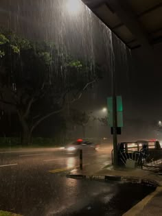 a car driving down a rain soaked street at night