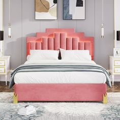 a bed with pink headboard and foot board in a room that has paintings on the wall